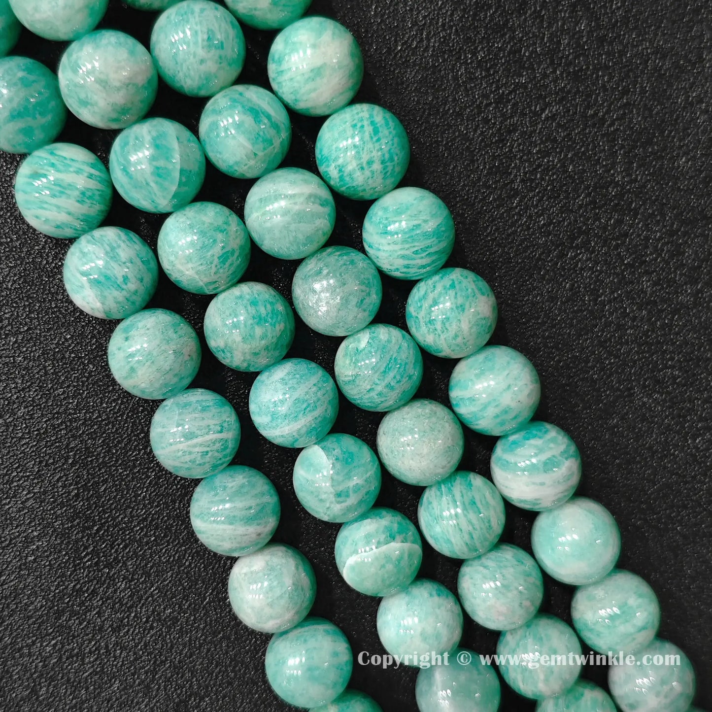 Angled view of natural Grade B amazonite 13-15mm large bead strands displaying polished texture