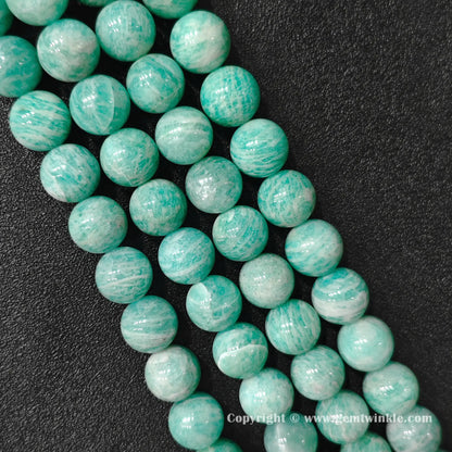 Angled view of natural Grade B amazonite 13-15mm large bead strands displaying polished texture