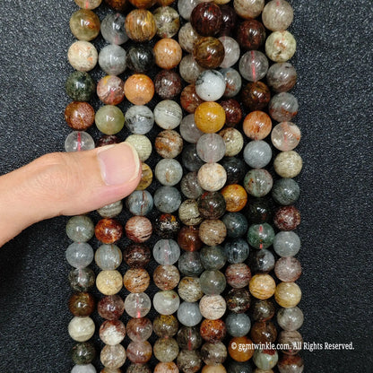 hand inspecting a large bundle of high quality 10mm natural multi phantom garden quartz loose strands