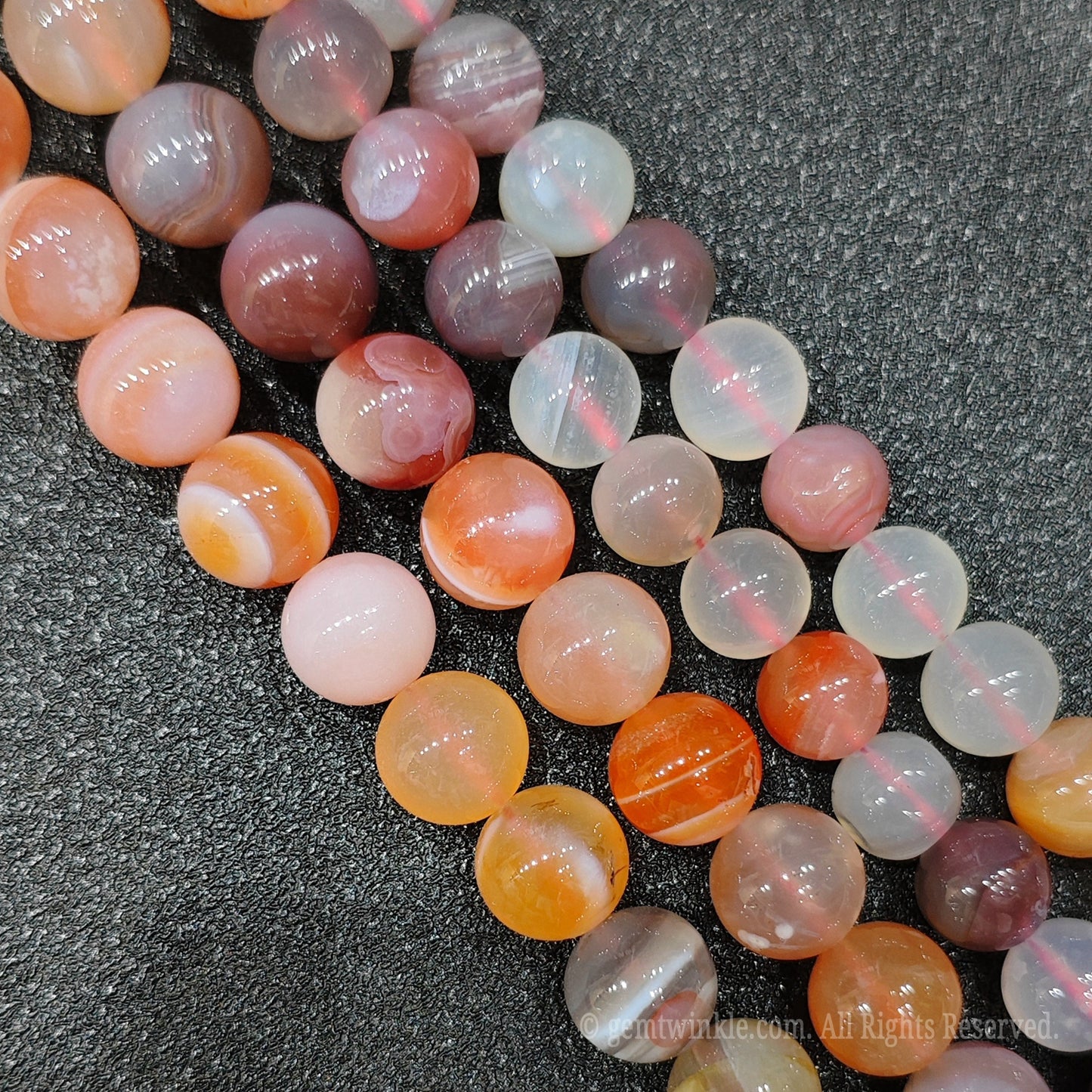 Handmade jewelry supplies showing premium hand selected red persian banded agate gemstone strand on a plain display background