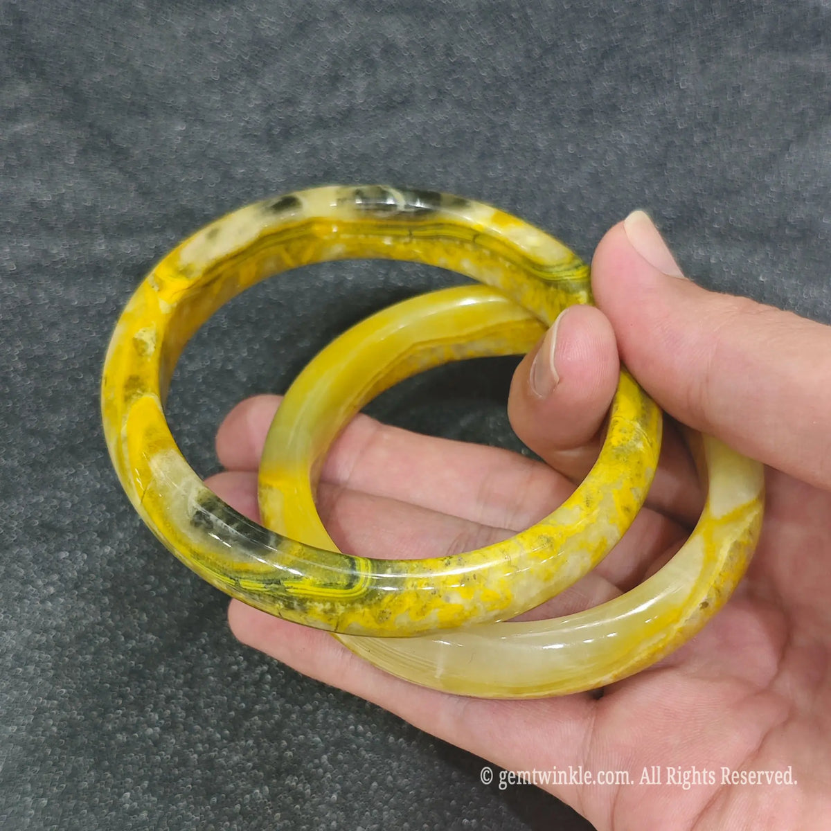 Pair of authentic Bumblebee Jasper carved stone bangles displaying bright yellow and charcoal swirl details