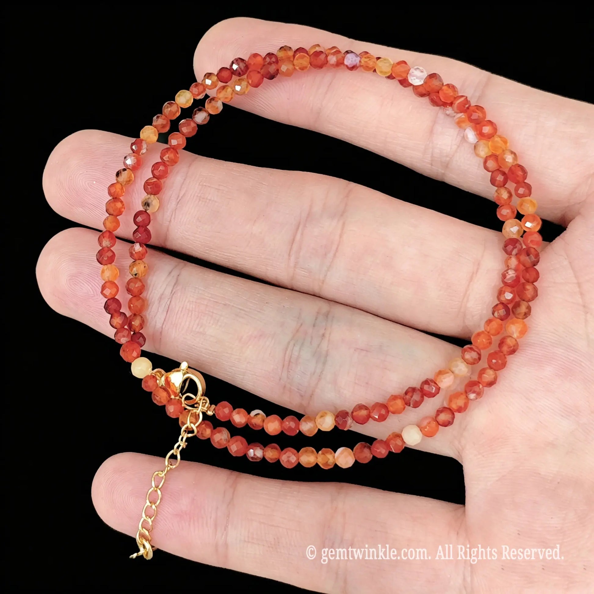single strand carnelian red banded agate collar necklace coiled across palm showing banded patterns