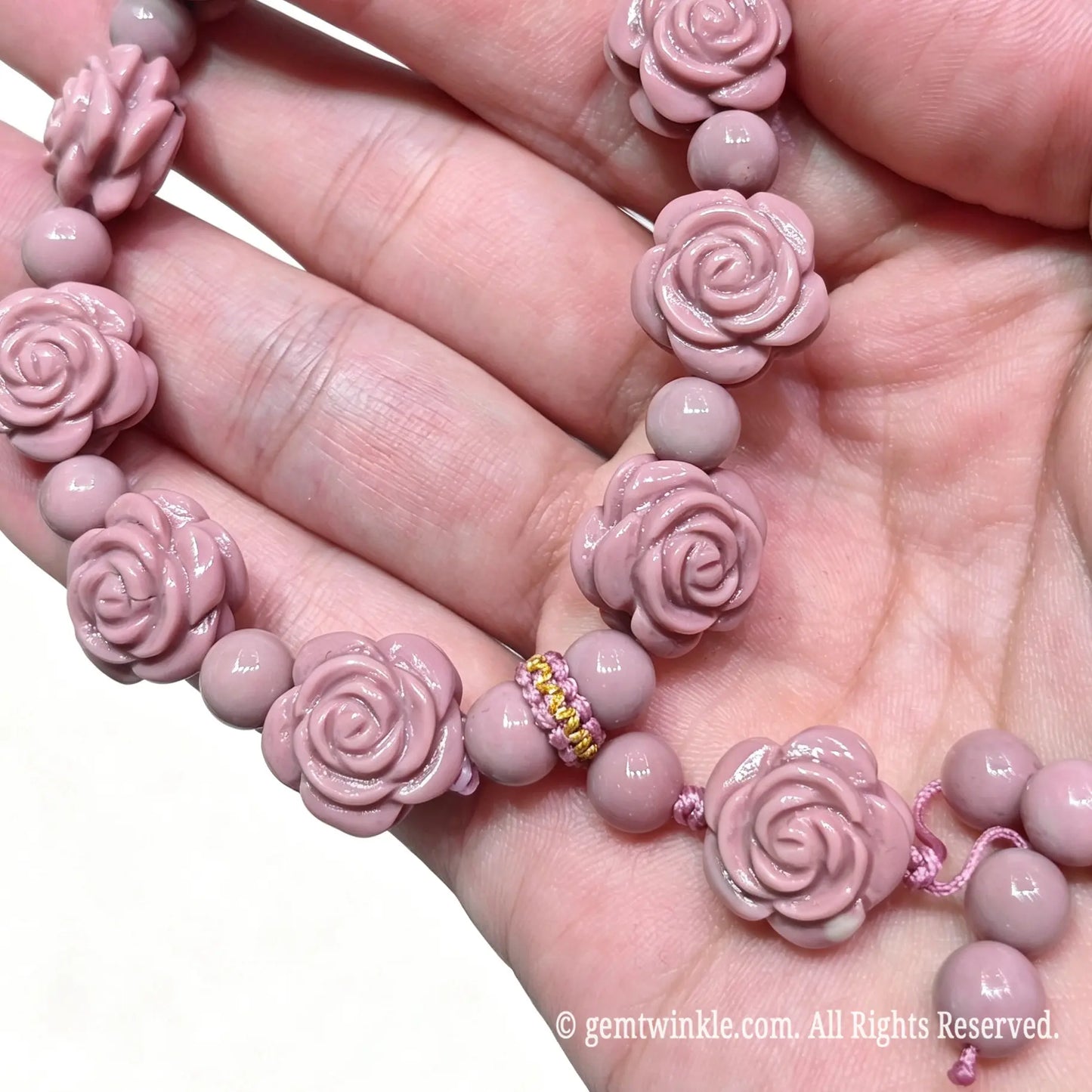 Close up preview of dusty pink Alashan agate rose carvings on bracelet strand