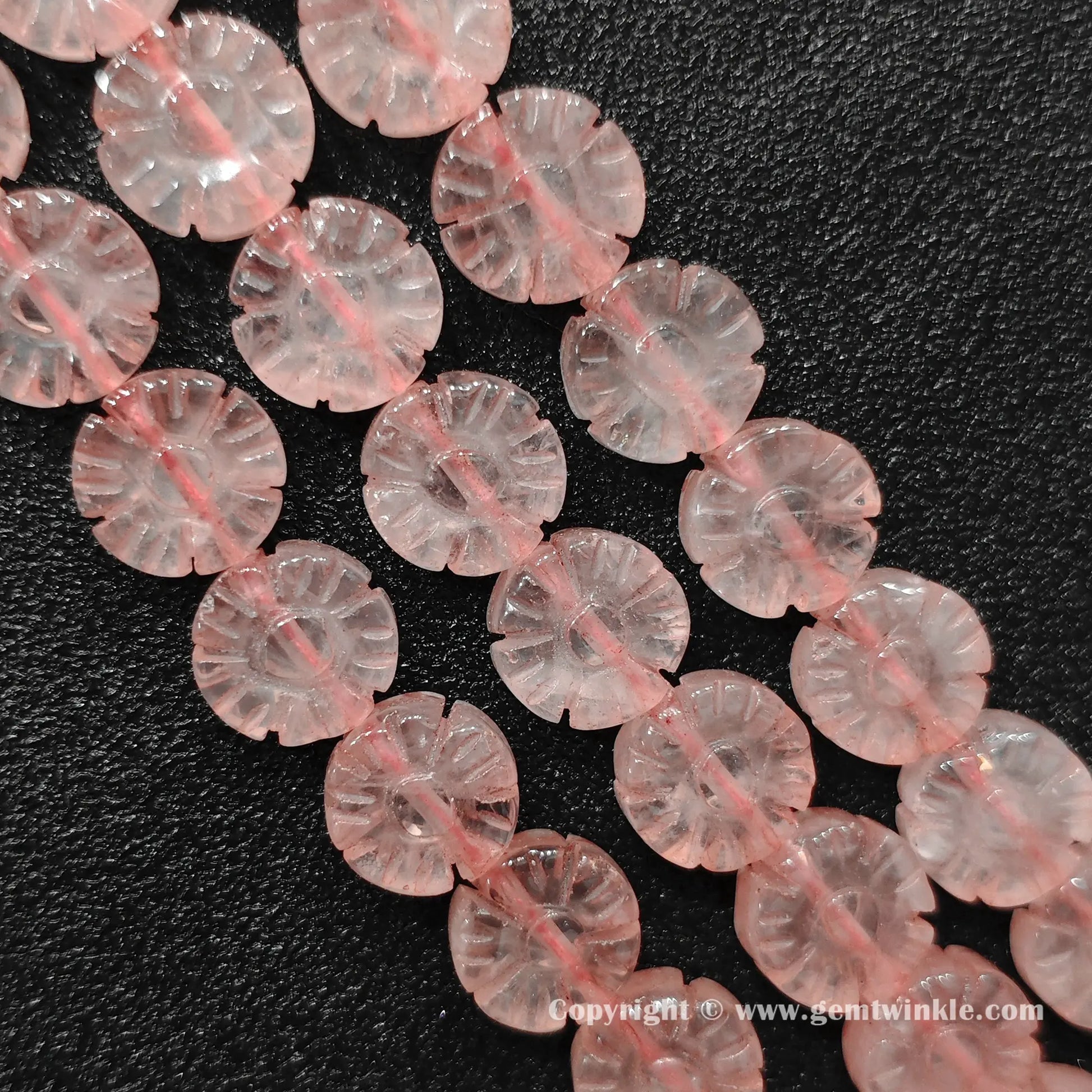 Natural rose quartz plum blossom flower bead strands laid on surface for quality preview