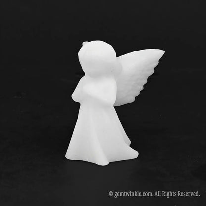 Angled view of a pocket sized carved white stone angel figurine suitable for baptism favors and wedding gifts