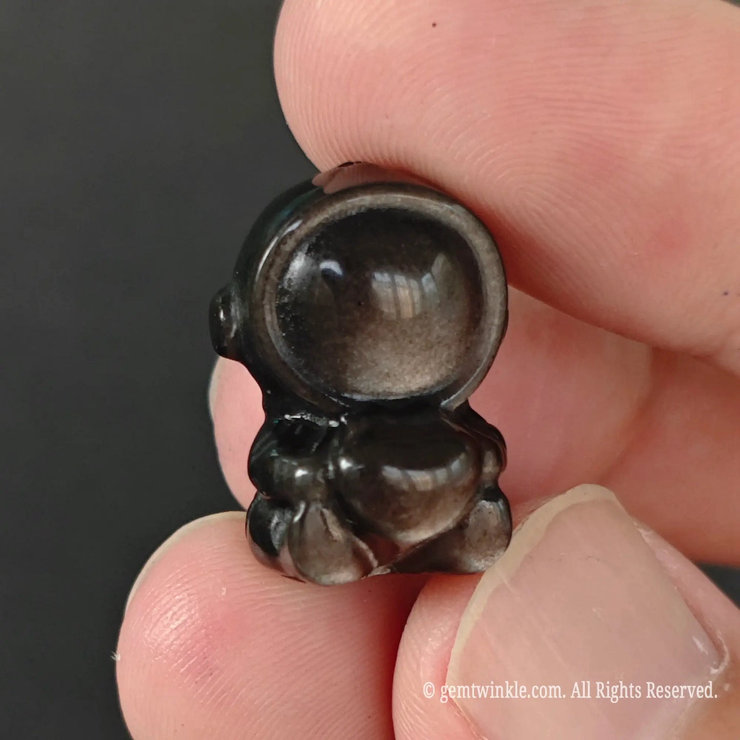 Carved 20mm silver sheen obsidian spaceman holding heart bead front view showing 3d body shape and smooth finish