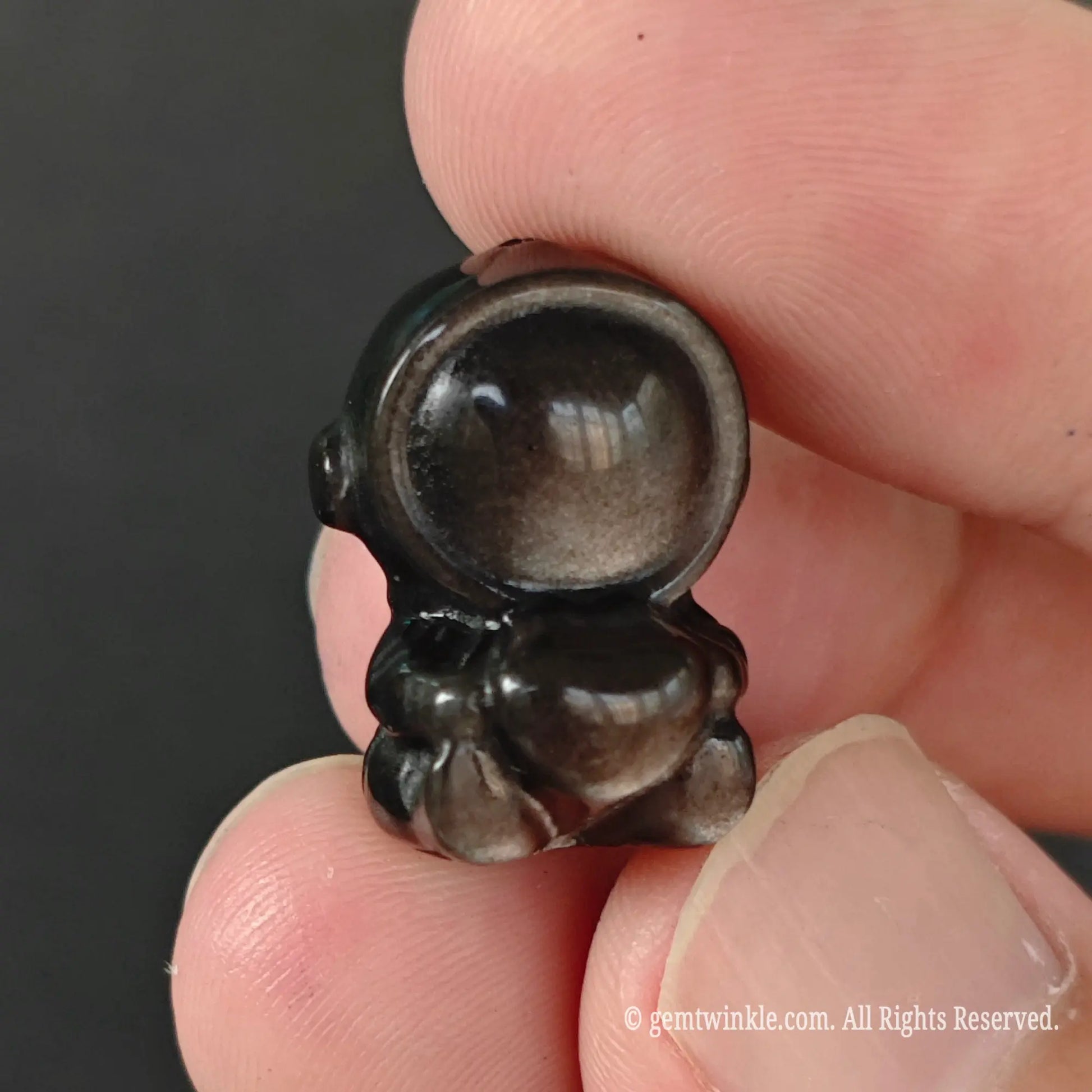 Carved 20mm silver sheen obsidian spaceman holding heart bead front view showing 3d body shape and smooth finish
