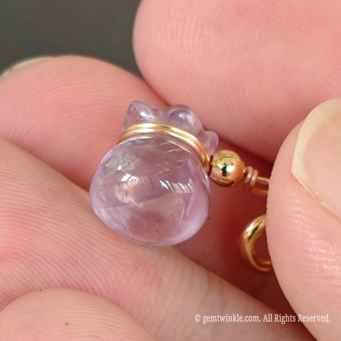Carved lavender amethyst pouch charm side view showing smooth polished crystal finish and 3d money bag shape