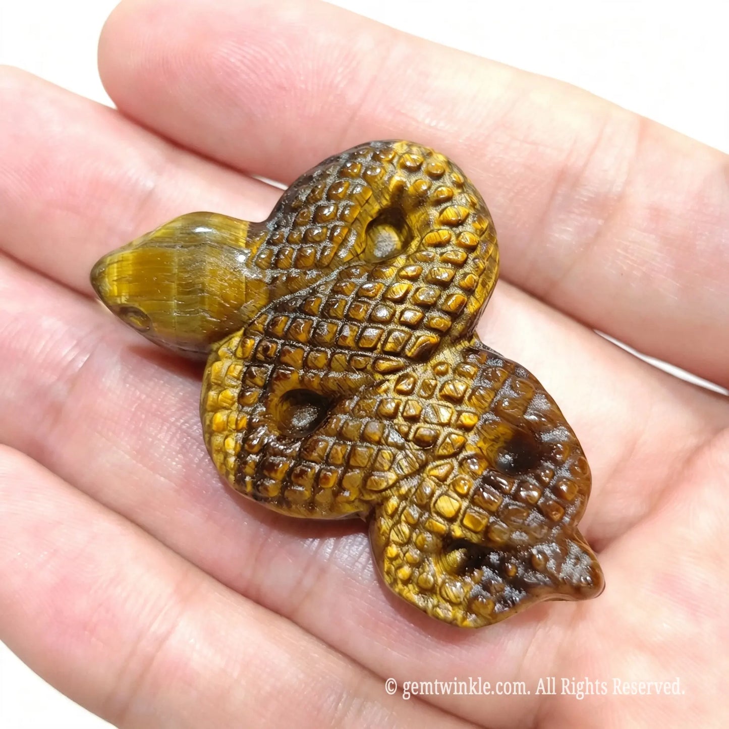 Hand holding carved yellow tiger eye snake figurine 5cm with flat bottom base for display