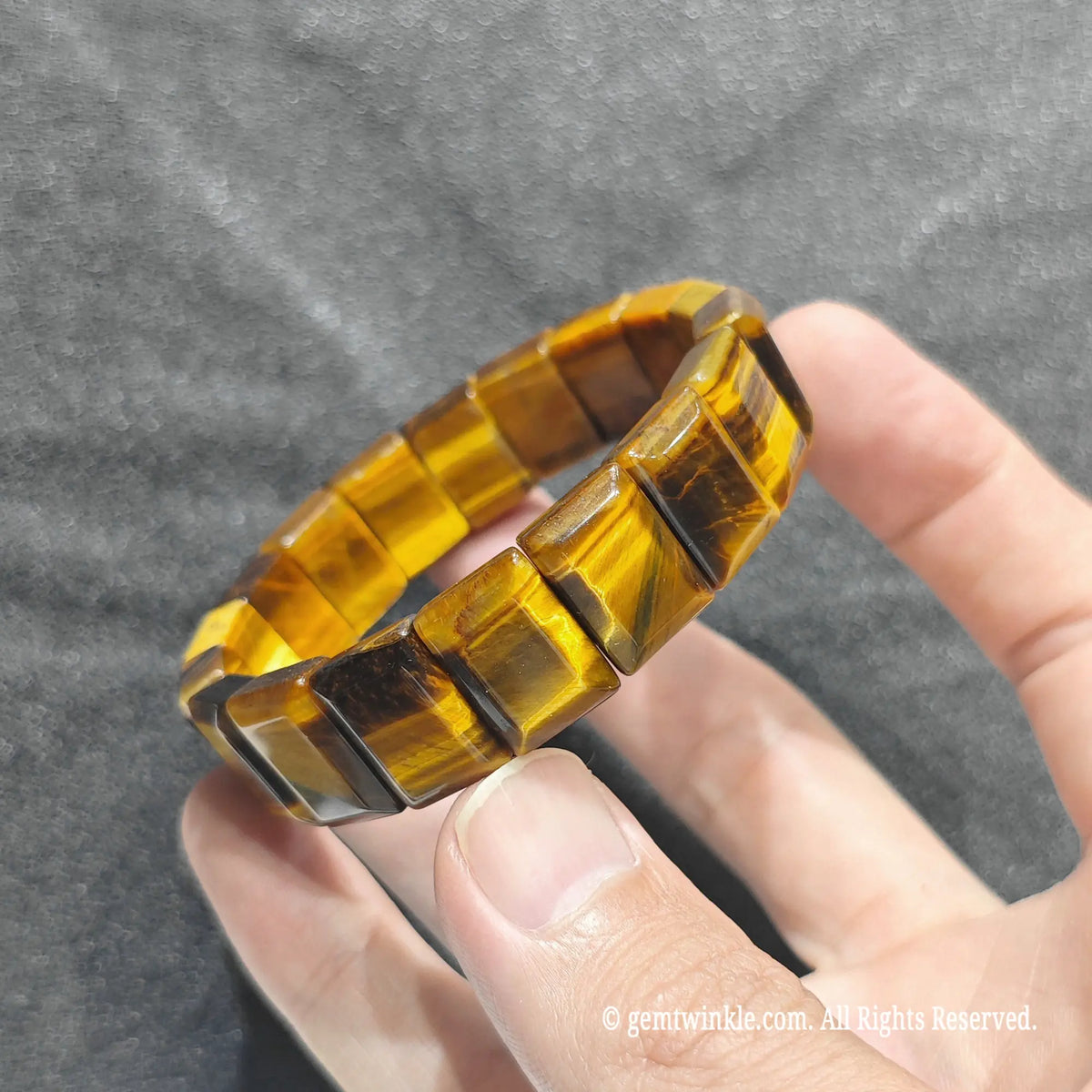 Close up view of chatoyant quartz rectangular bead wristband showing polished flat plate beads
