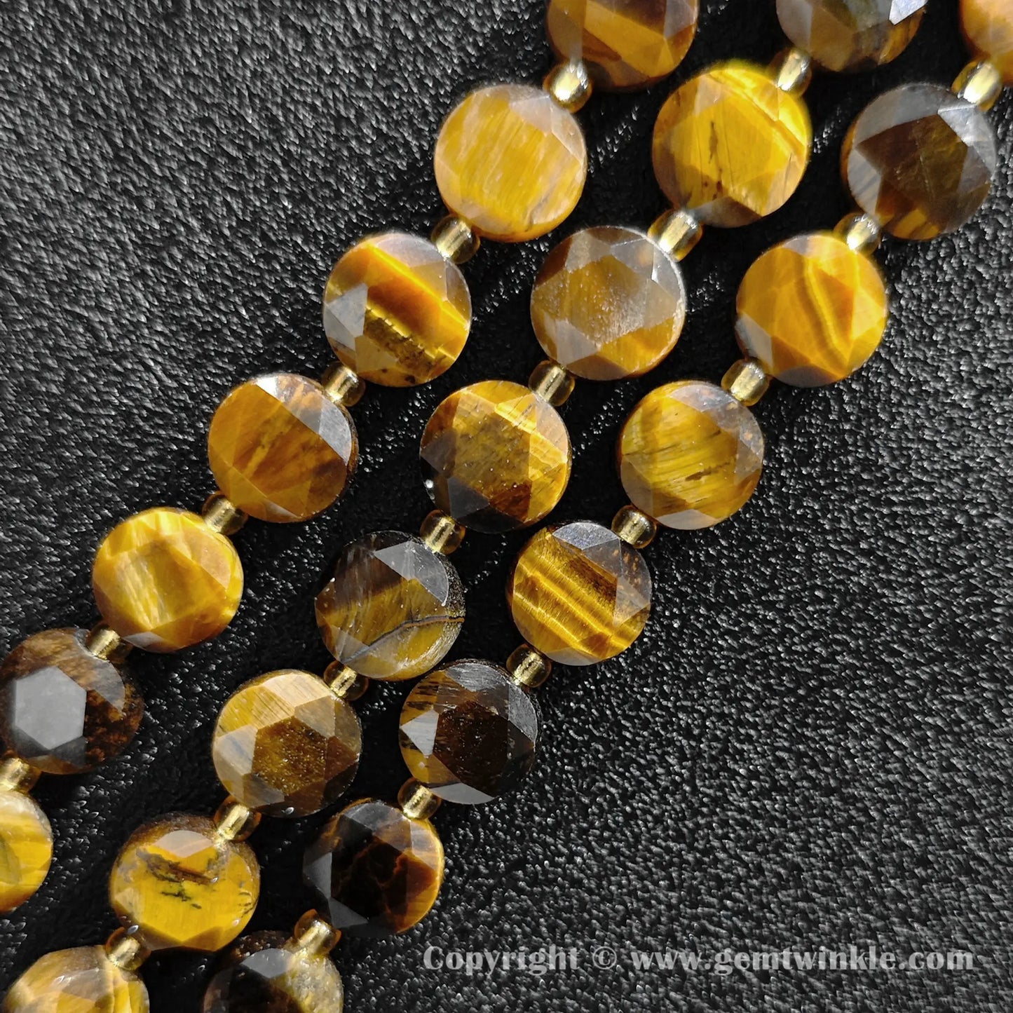 Close up view of golden chatoyant tiger eye star faceted flat wheel beads