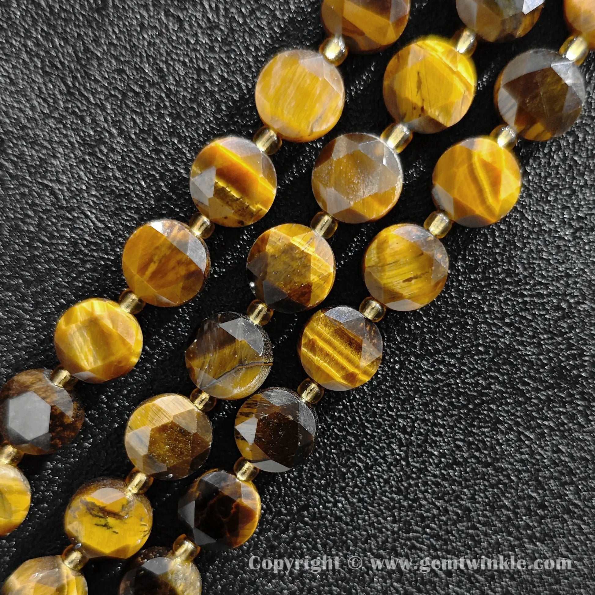 Close up view of golden chatoyant tiger eye star faceted flat wheel beads