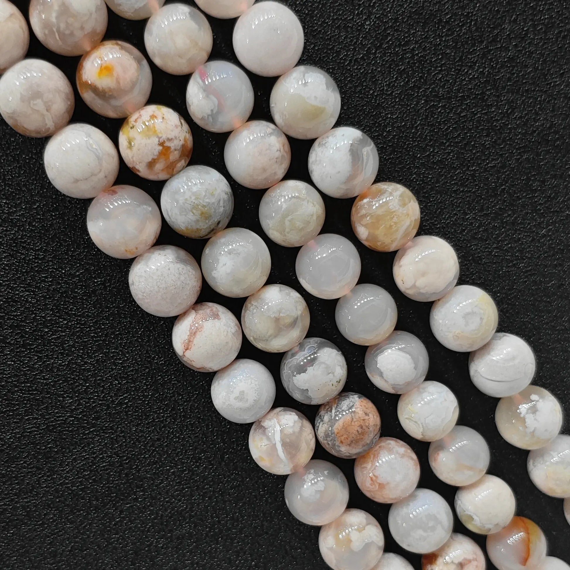 Close up view of genuine cherry blossom agate smooth round beads strands highlighting natural pink and white floral plumes in image_bdfdc7.jpg