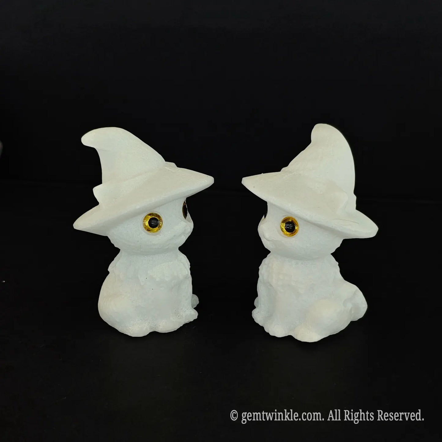Two white marble chibi wizard kitten figurines facing each other in profile showcasing the curves of the pointed witch hats