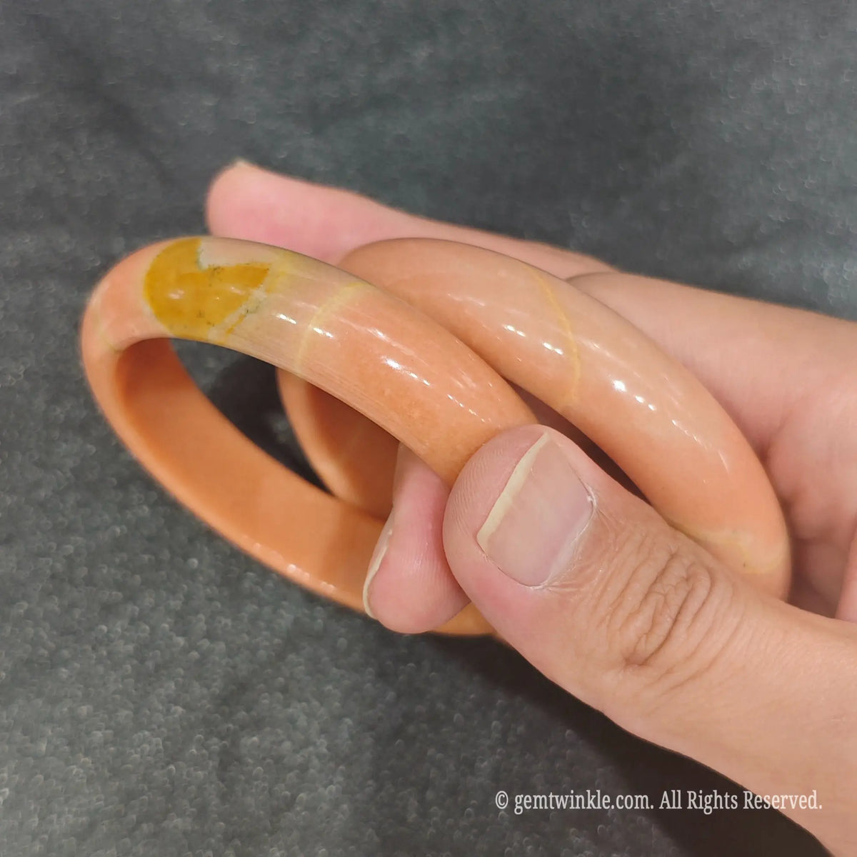 Pair of authentic carved Apricot Quartz bangles displaying warm orange yellow mineral pattern