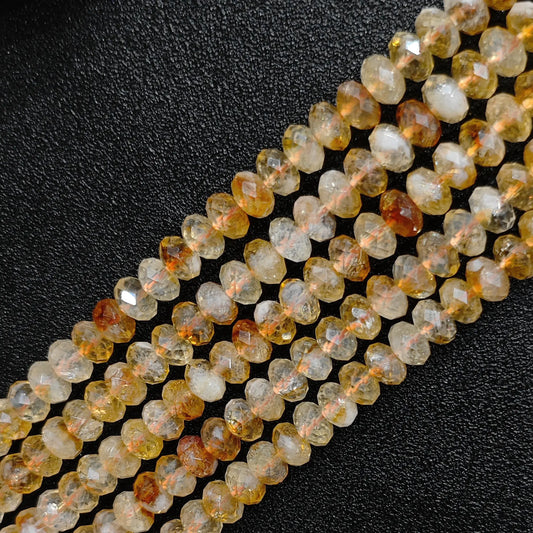 Macro closeup of citrine faceted rondelle beads showing golden yellow tone and cut facets