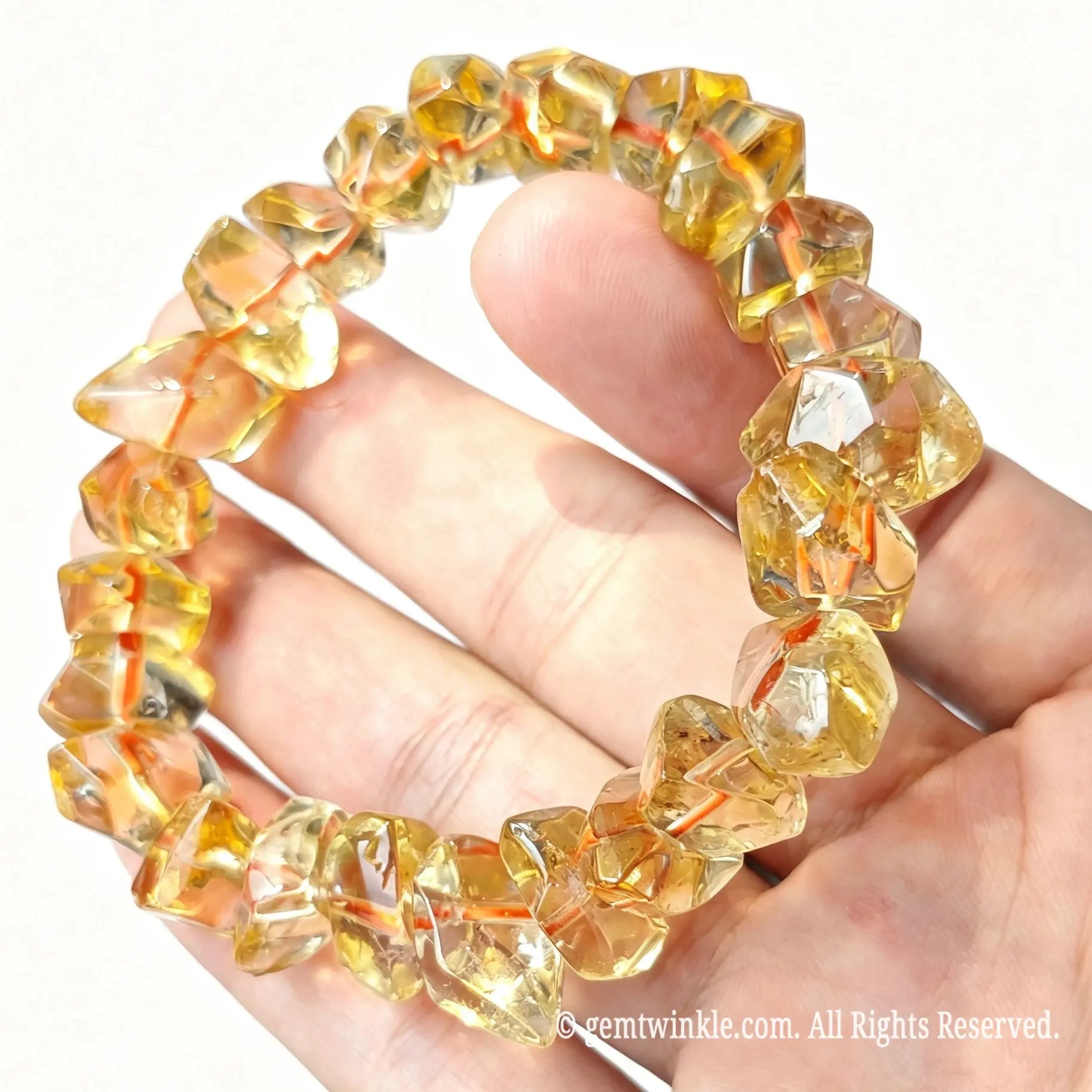 Handheld perspective of golden freeform citrine quartz nugget bracelet displaying natural crystal facets