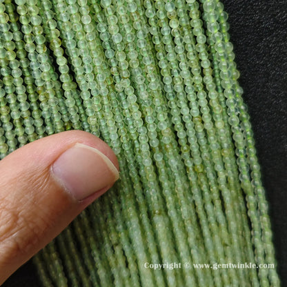 Close up view of clean 3mm prehnite round beads inspected on hand for color preview