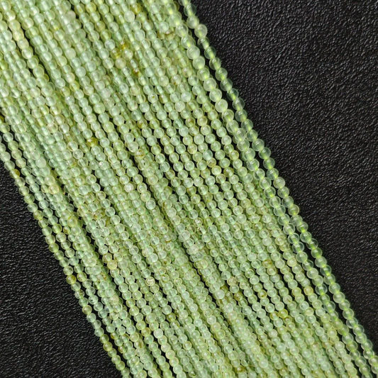 Macro closeup of clean prehnite smooth round seed beads 3mm showing translucent green body free of black spots