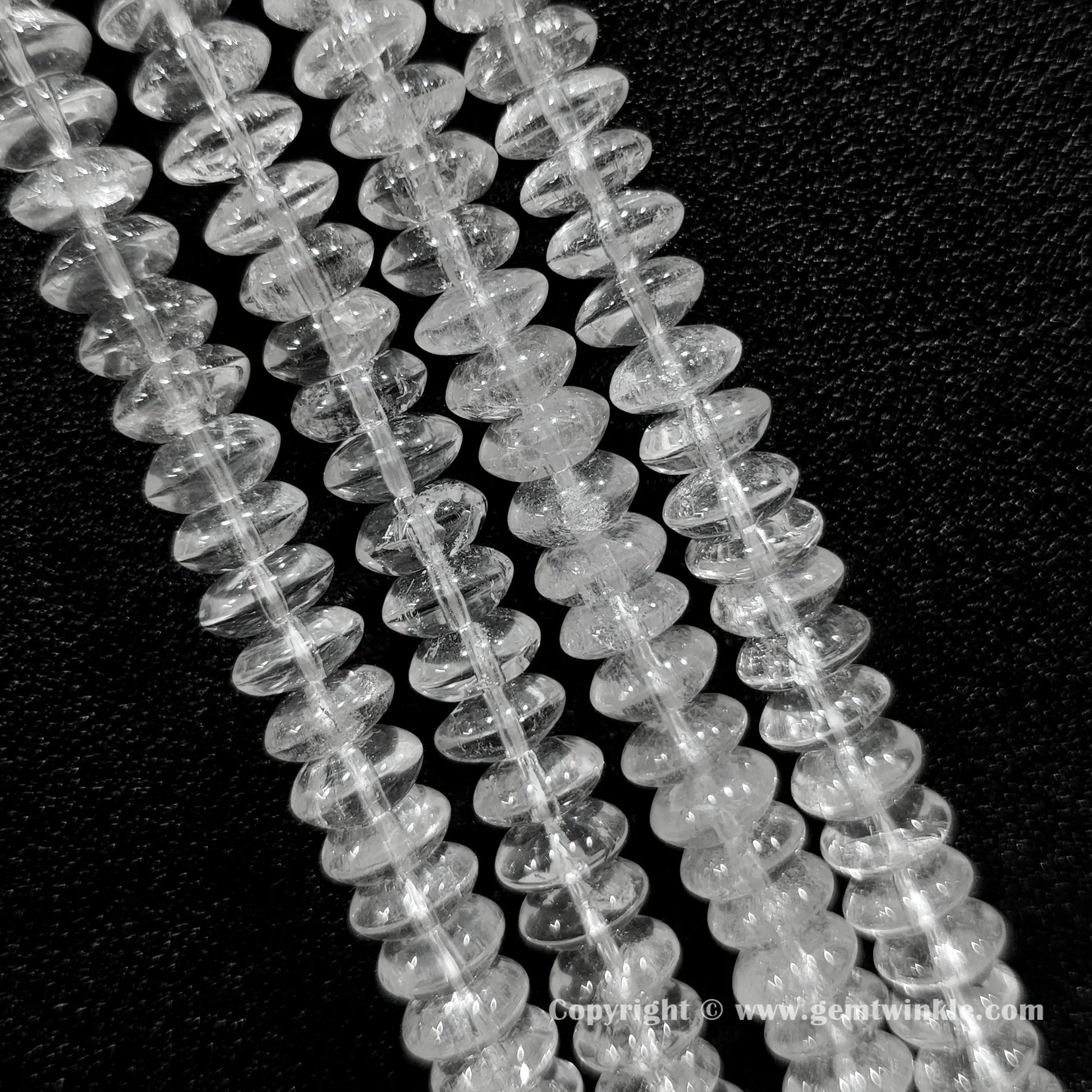 Natural clear quartz rondelle bead strand held over hand showing size scale