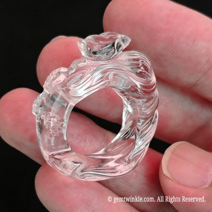 Hand preview of a carved clear quartz fox ring showing ice-like optical clarity and smooth surface finish
