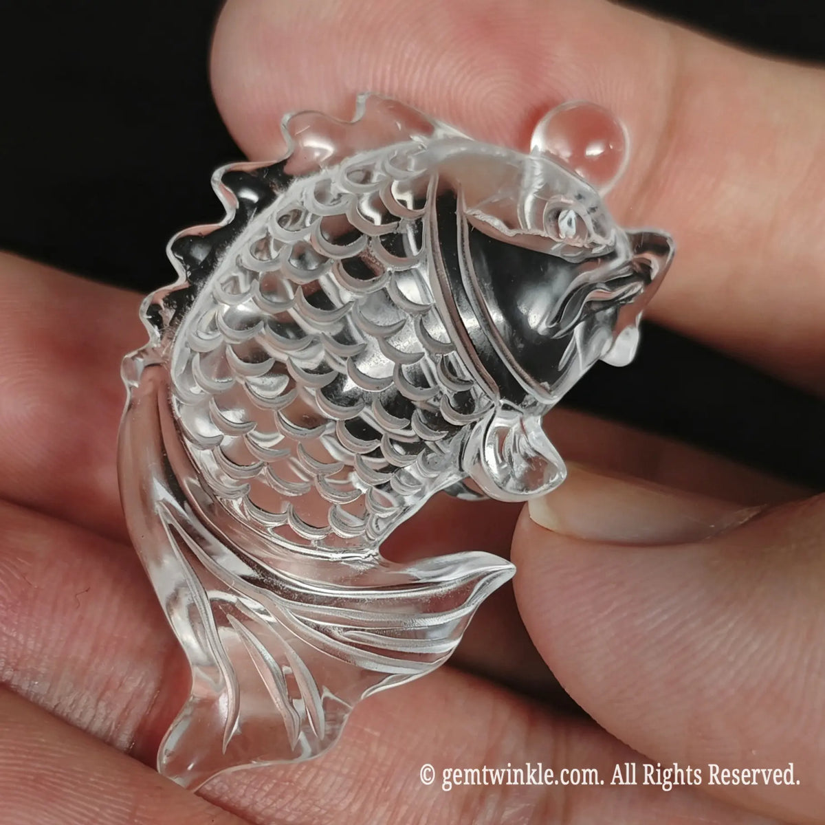 Back view of clear quartz koi fish carving showing smooth polished contours and tail curve