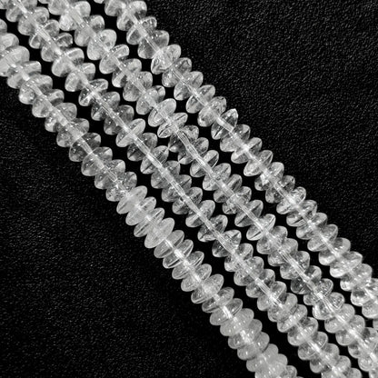 Macro closeup of natural clear quartz rondelle disc beads showing internal ice cracks and cotton-like veils