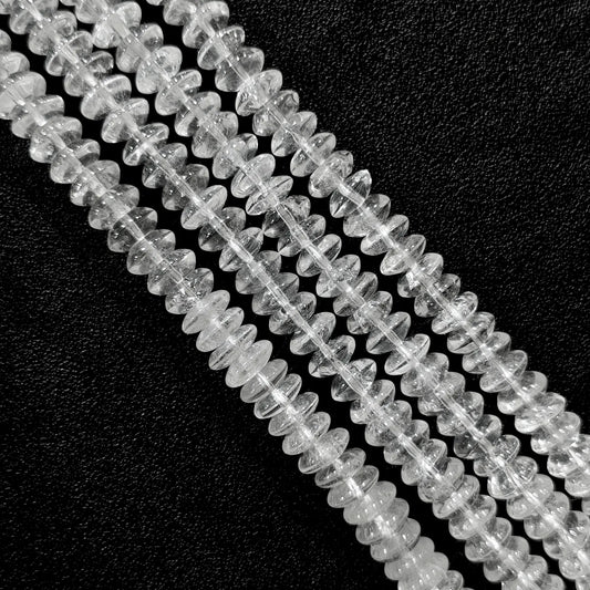 Macro closeup of natural clear quartz rondelle disc beads showing internal ice cracks and cotton-like veils