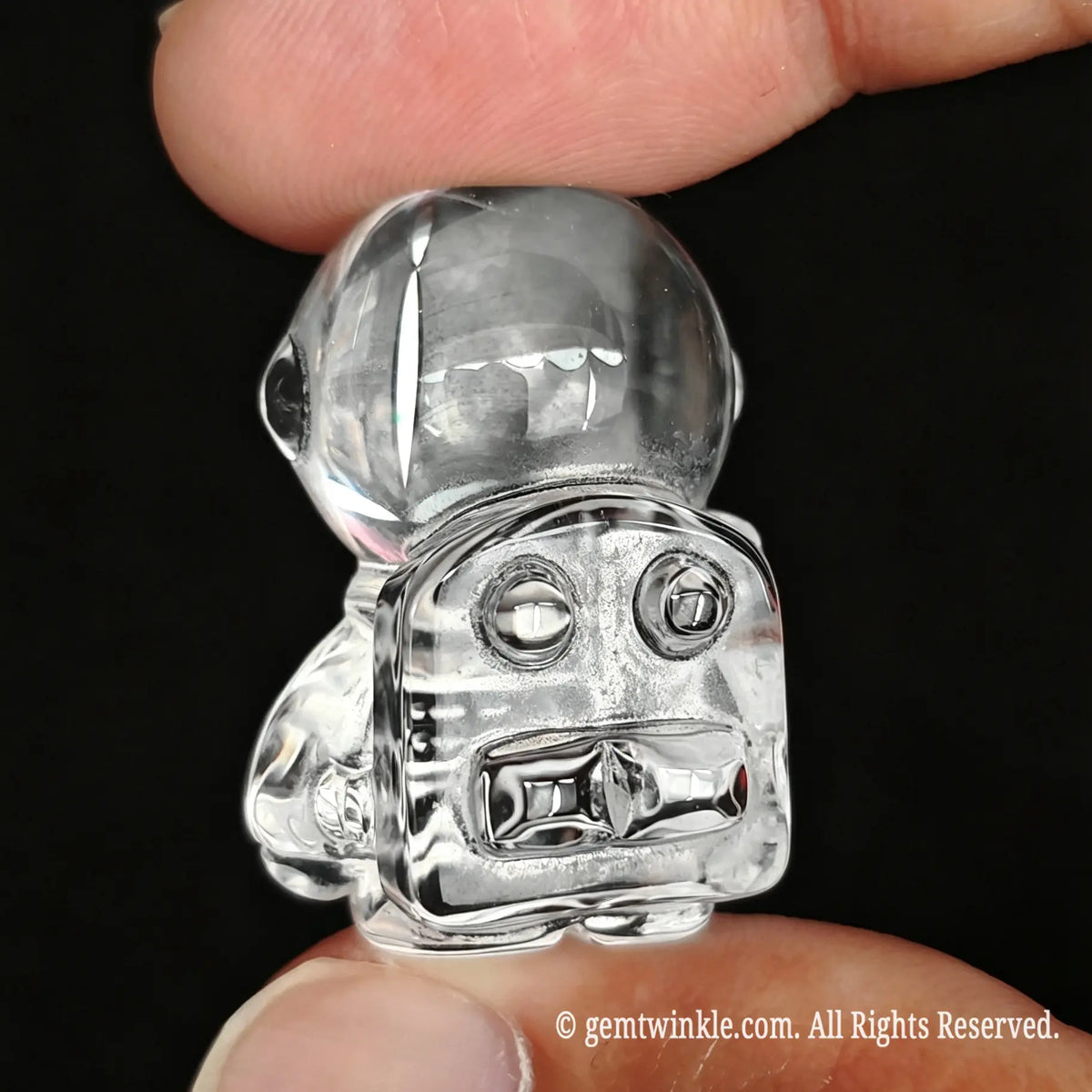 Back view of clear quartz astronaut figurine showing sculpted oxygen pack detail