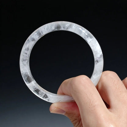 Close up view of clear quartz white phantom bangle showing smooth polished curvature and natural snowy landscape matrix