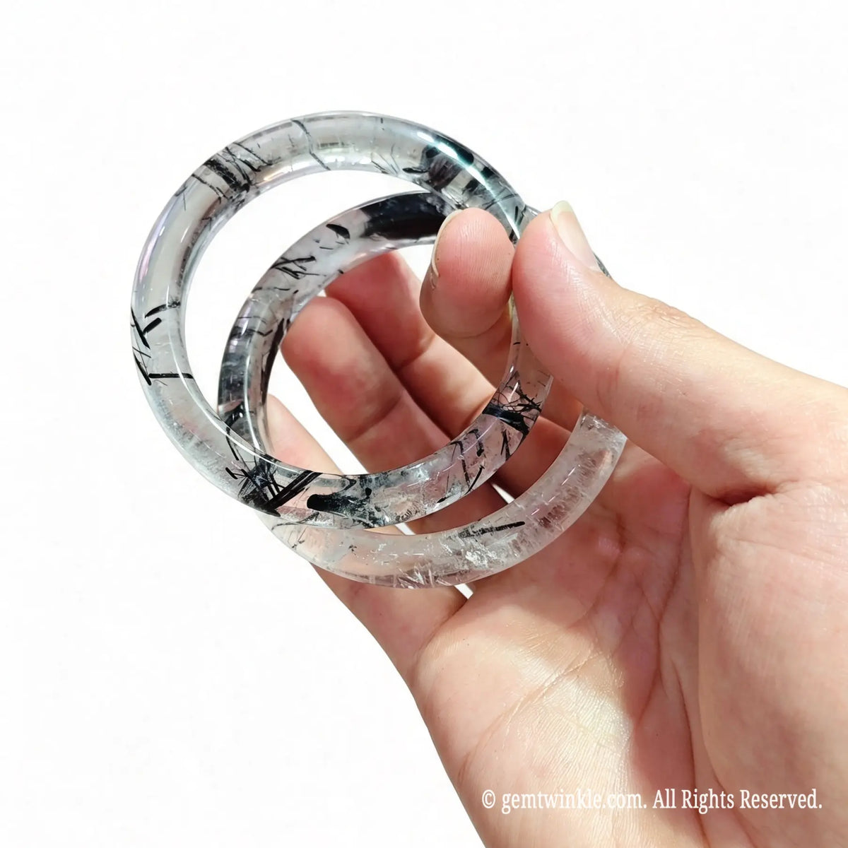 Clear black rutile gemstone band held in hand showing translucent clarity and single piece custom selection