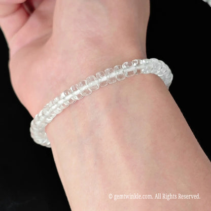 Full display view of clear quartz 5.5-6mm straight cut disc bead bracelet highlighting bright light refraction