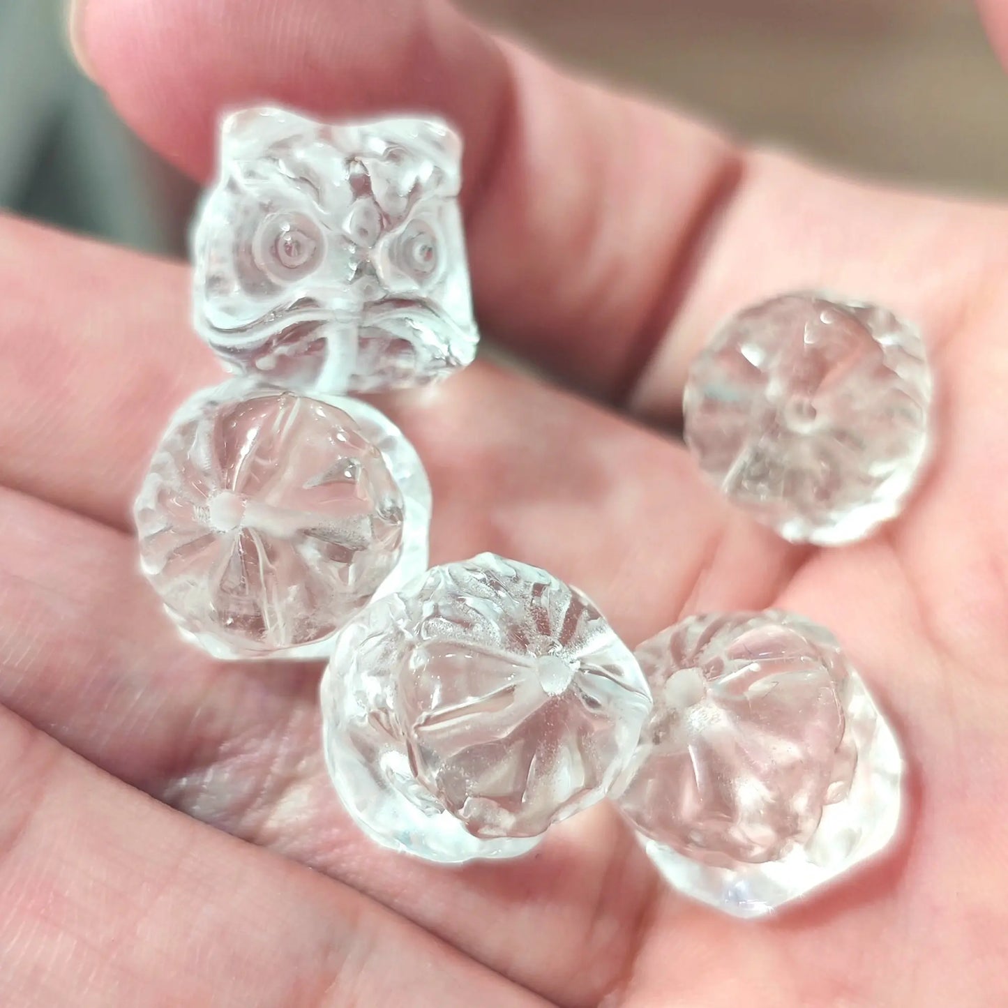 Clear quartz guardian lion beads in hand showcasing transparent body and carved mane textures