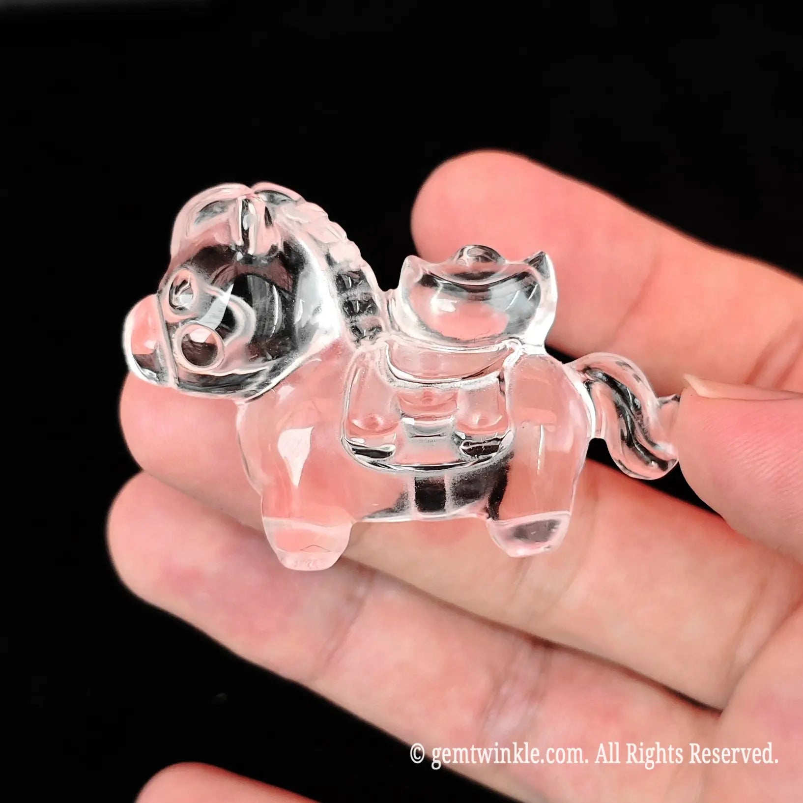 Close up view of translucent clear quartz horse carving showing light refraction and minor internal wispy inclusions