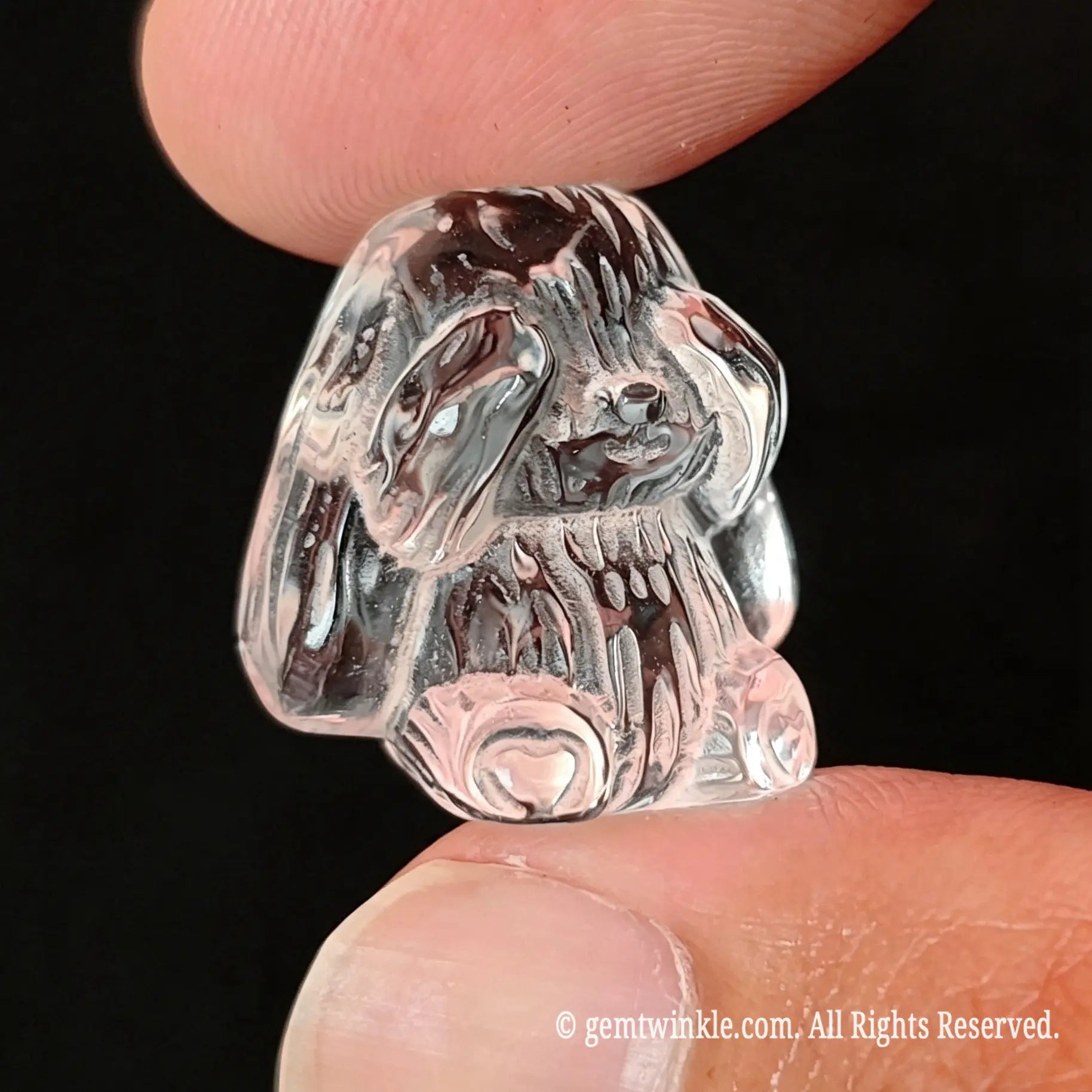 Close up side view of translucent clear quartz rabbit carving showing light refraction and detailed ear relief