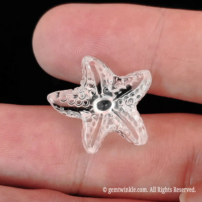 Close up view of translucent clear quartz sea star carving showing light refraction and fine surface texture