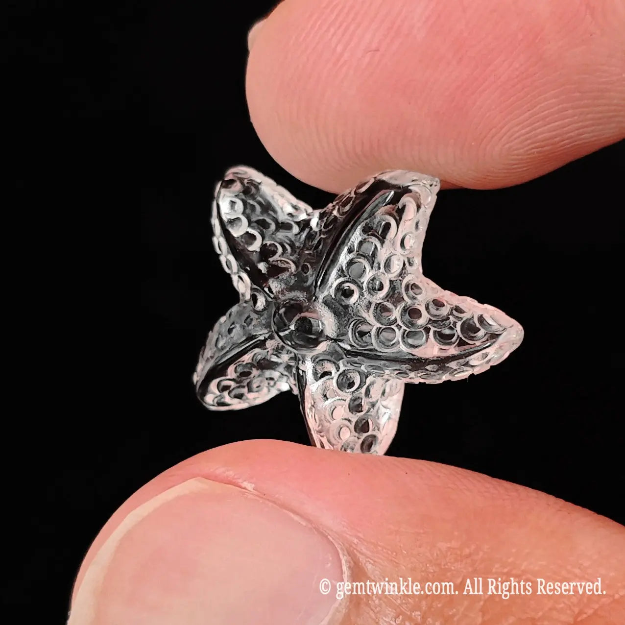 Close up view of translucent clear quartz sea star carving showing light refraction and fine surface texture