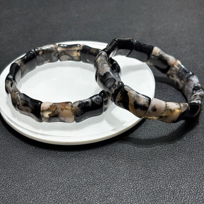 Close up detail of black sakura agate beads with bamboo shape.