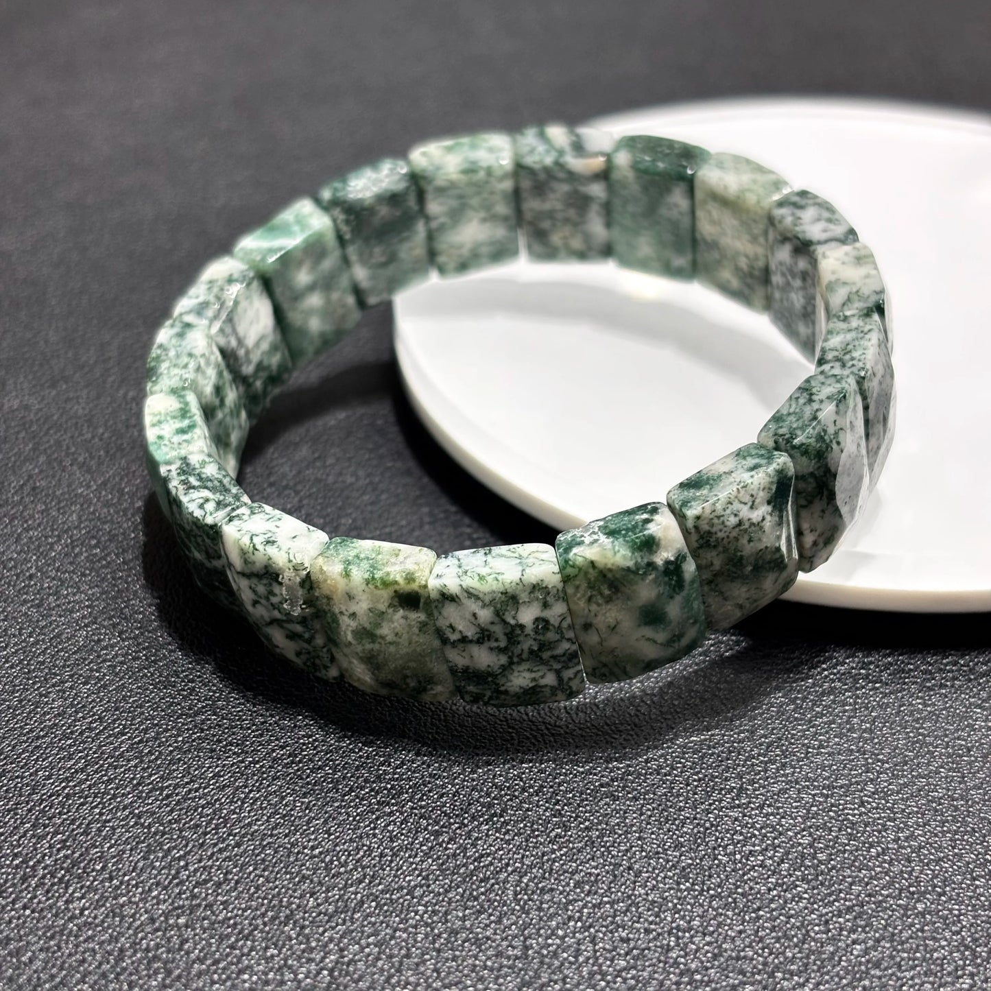 Close-up view of the natural green moss agate bamboo bracelet, showing the intricate moss-like inclusions and square bead shape.
