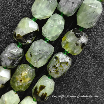 close up of faceted translucent green prehnite cylinder beads with dark inclusions