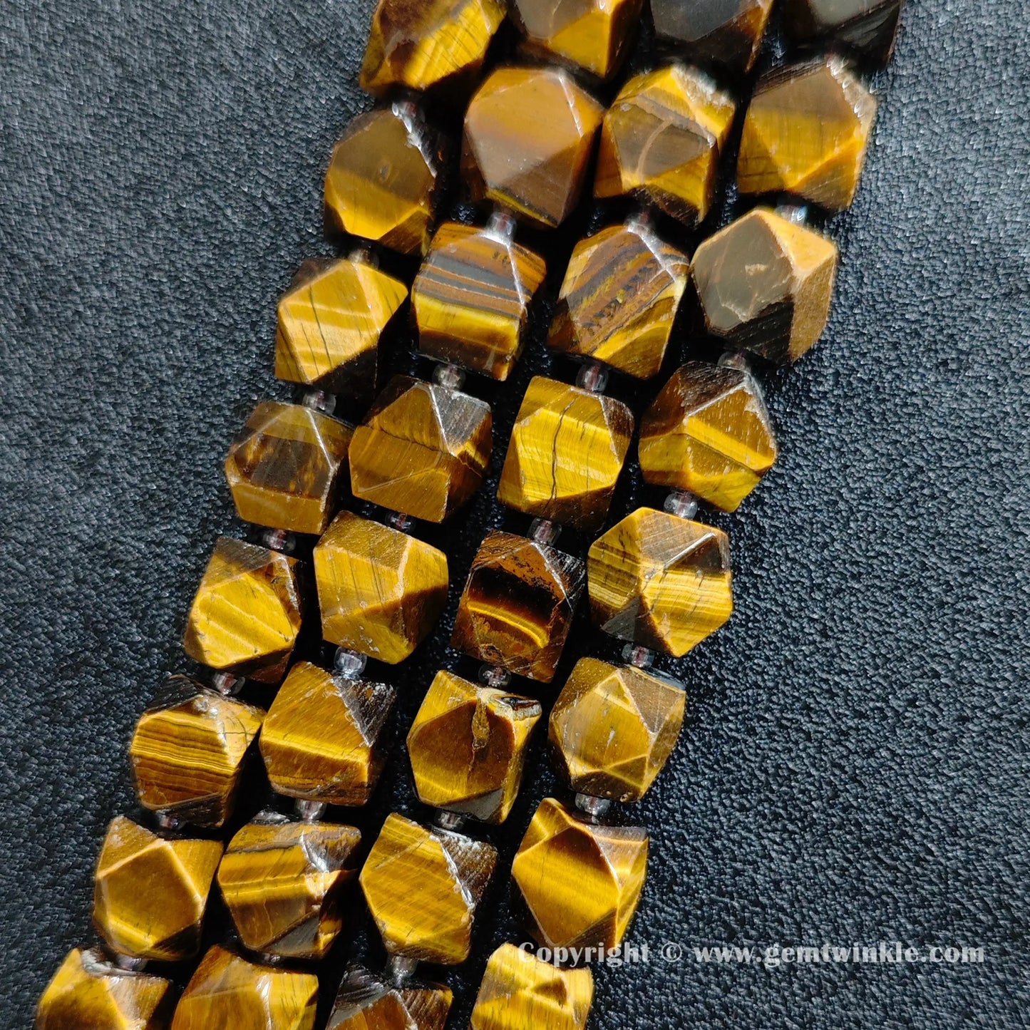 close up of golden tiger eye cylinder beads showing chatoyant sheen