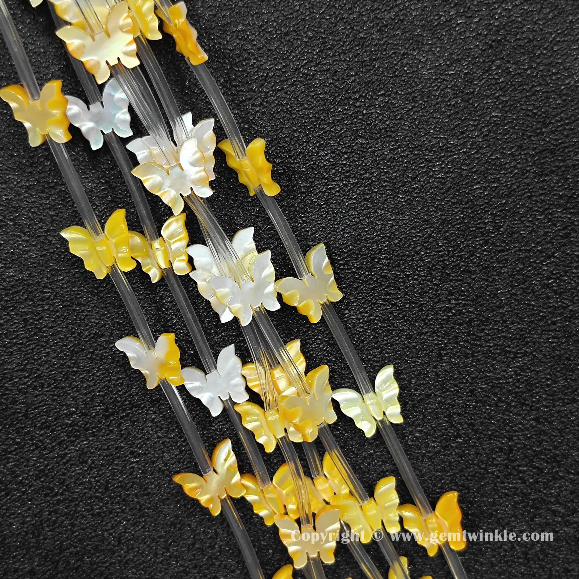 close up of golden yellow shell machine carved butterfly charms