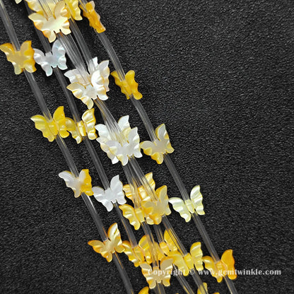 close up of golden yellow shell machine carved butterfly charms