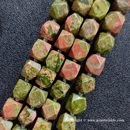 close up of green and pink unakite cylinder beads showing mottled matrix