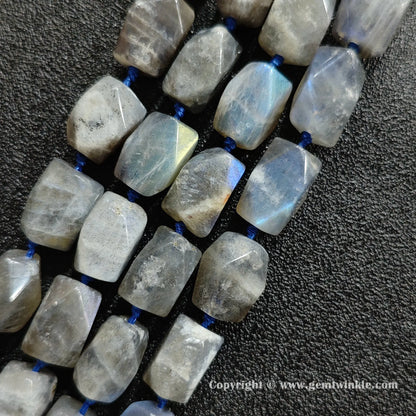 close up of raw cut grey moonstone cylinder beads with blue schiller flash