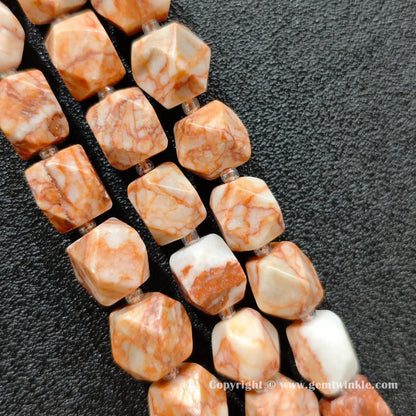 close up of terracotta red vein stone cylinder beads showing dark veining