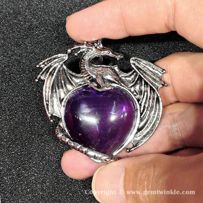 Hand holding 5cm dragon heart amethyst pendant with visible natural internal cloud inclusions