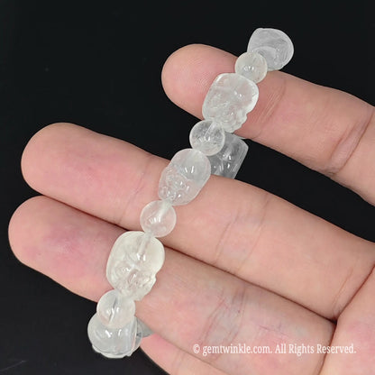 top view of semi translucent cloudy quartz pixiu stretch bangle held in palm