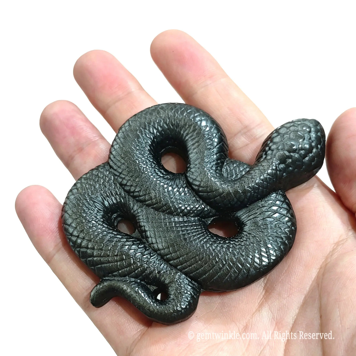 Top view of coiled serpent statue carved from silver sheen obsidian in hand displaying S-curve body shape