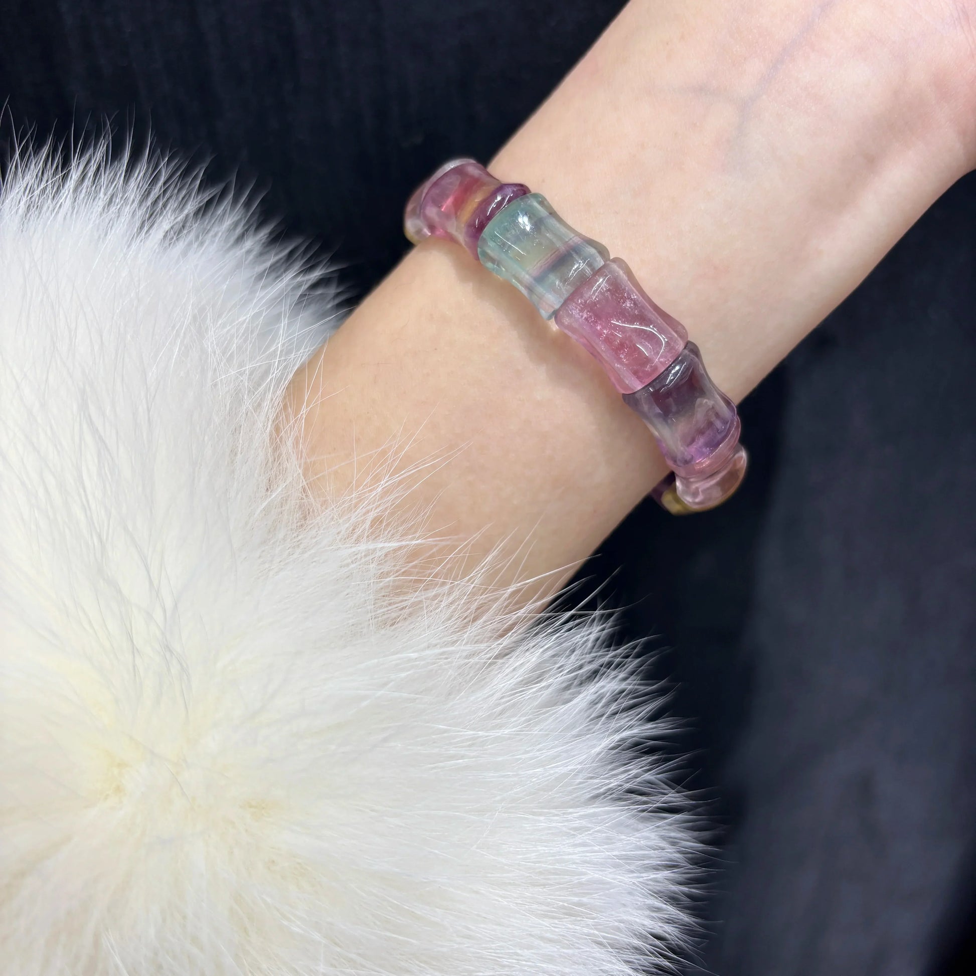Woman wearing Natural Colorful Fluorite Bamboo Bead Bangle Bracelet on wrist, soft white fur background, elegant and stylish